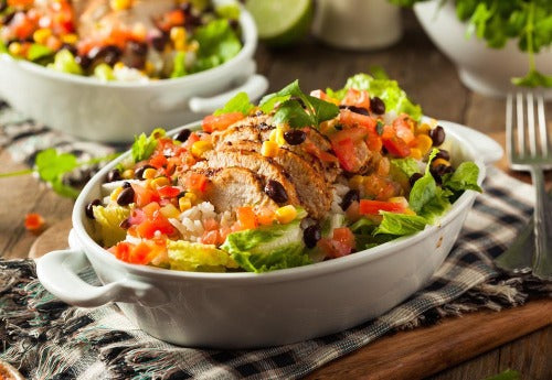 Chicken Chipotle. Tender roasted chicken is served over a power greens with the perfect southwest combination of black beans, roasted corn, Spanish rice, tomatoes and topped with cilantro. Topped with cheddar cheese and served with a side of queso blanco