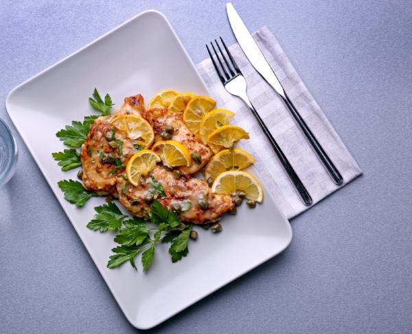 Organic chicken breast are seasoned with spices, lightly floured with almond flour pan fried, and topped with parmesan cheese. Served with lemon caper piccata sauce on the side.  This is a fantastic recipe that is low in calories and low in carbs, served over power greens, zoodles and veggies. Light, delicious, healthy meal.