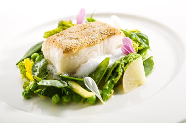 Almond Crusted Halibut - Low Carb Our tender, flaky fresh halibut is crusted with almonds and pan seared  creating an outstanding flavor served with sautéed vegetables over power greens, served with roasted red pepper gouda sauce