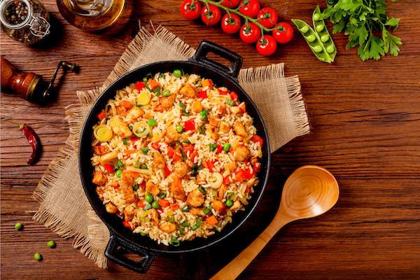 Chicken Fried Rice. Our tender grilled chicken is tossed with Asian fried rice, eggs, carrots, peas, corn, onions, green onions, bok choy, teriyaki, garlic, parsley, basil, sesame seed oil, pepper, soy sauce, lime, olive oil.   You cannot go wrong with this delicious healthy dish. This delicious meal can be enjoyed as an entree and big enough for two.